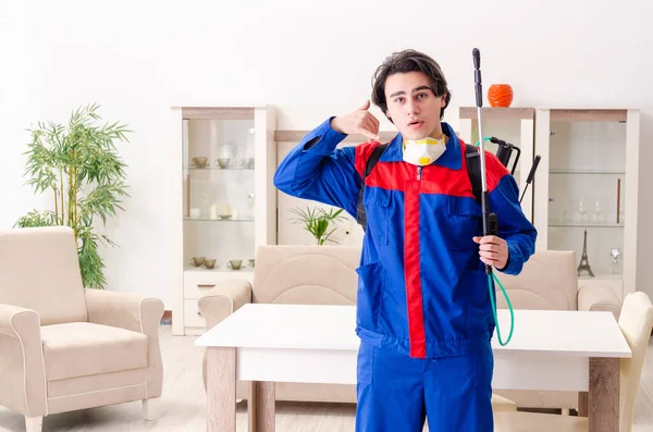 Jovem empreiteiro fazendo controle de pragas em casa — Fotografia de Stock