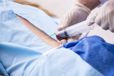 Kadın hasta klinikte iğne oluyor.