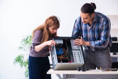 Two repairmen repairing desktop computer clipart