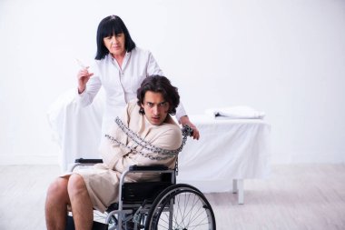 Yaşlı kadın psikiyatrist genç erkek hastayı ziyaret ediyor