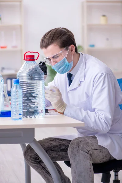 Jovem químico do sexo masculino experimentando em laboratório — Fotografia de Stock