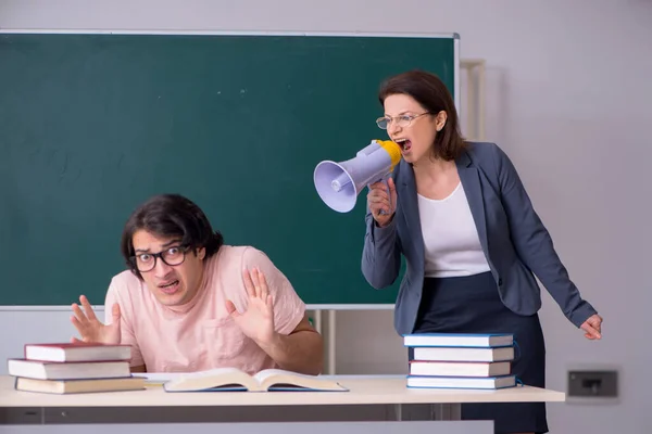 Velha professora e estudante do sexo masculino na sala de aula — Fotografia de Stock