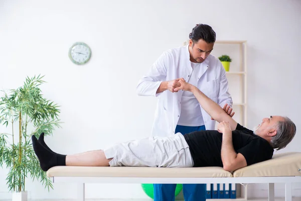 Viejo hombre herido visitando joven médico — Foto de Stock