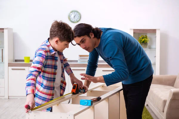 Jovem carpinteiro ensinando seu filho — Fotografia de Stock