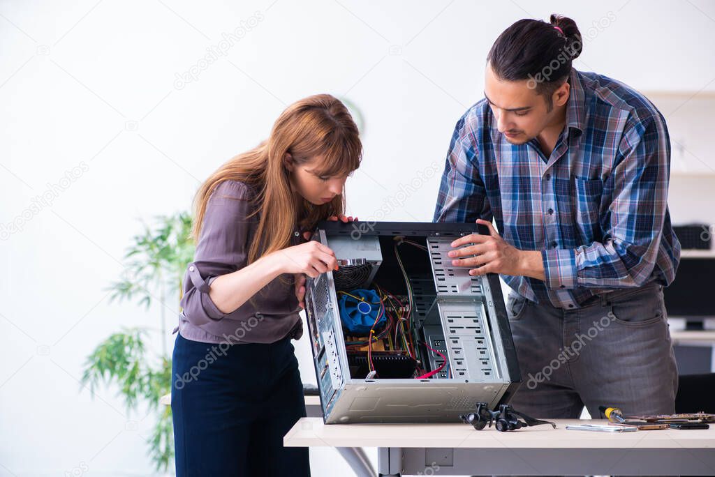 Two repairmen repairing desktop computer