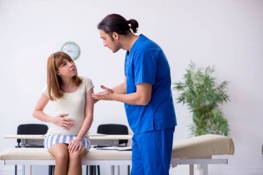 Hamile kadın, erkek doktor jinekoloğu ziyaret ediyor.
