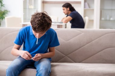 Genç bir çocuk ve ailesiyle sigara içme kavramı