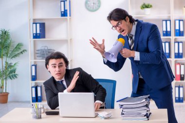 Patron ve erkek asistanı ofiste çalışıyor.