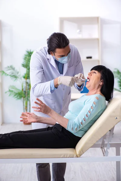 Vieja mujer visitando joven médico dentista — Foto de Stock