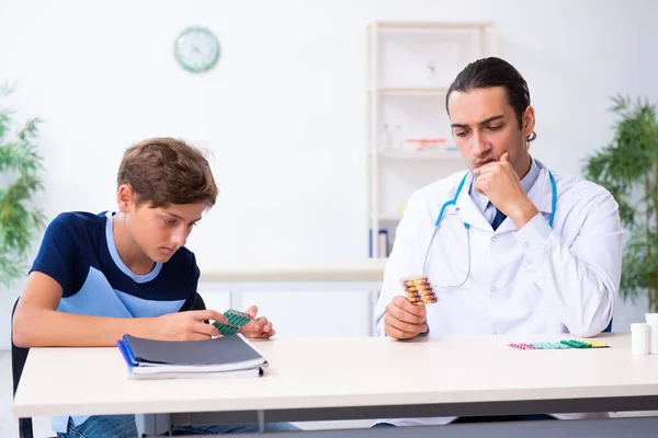 Jonge mannelijke arts onderzoeken jongen in de kliniek — Stockfoto