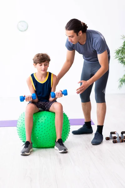 Jovem pai e seu filho fazendo exercícios — Fotografia de Stock