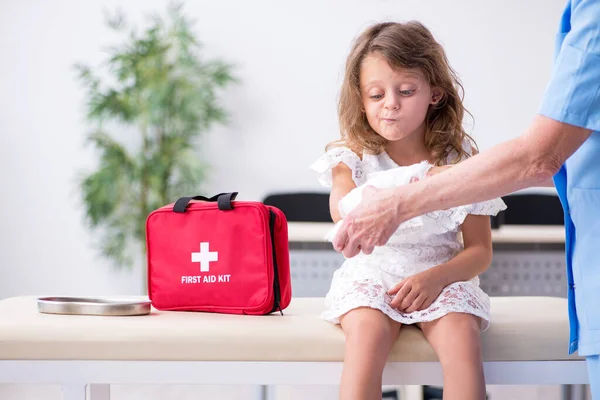 Petite fille visitant un vieux médecin féminin — Photo