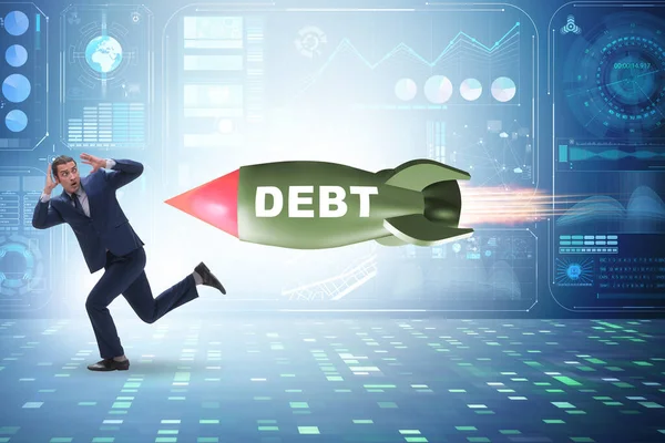 Концепция кредита и долга с бизнесменом, преследуемым ракетой — стоковое фото