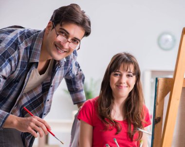 Stüdyoda resim sınıfında sanatçı koçluğu yapan bir öğrenci.