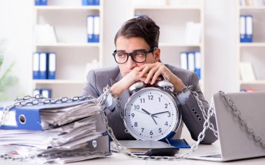 Ofis masasına zincirlenmiş meşgul bir çalışan.