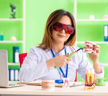 Diş implantı üzerinde çalışan kadın dişçi.