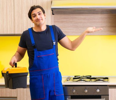 Genç müteahhit mutfak mobilyalarını monte ediyor.