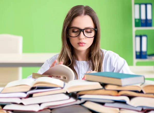 Młoda studentka przygotowująca się do egzaminów z wielu książek — Zdjęcie stockowe