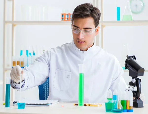 Студент молодого хіміка, який працює в лабораторії з хімічних речовин — стокове фото
