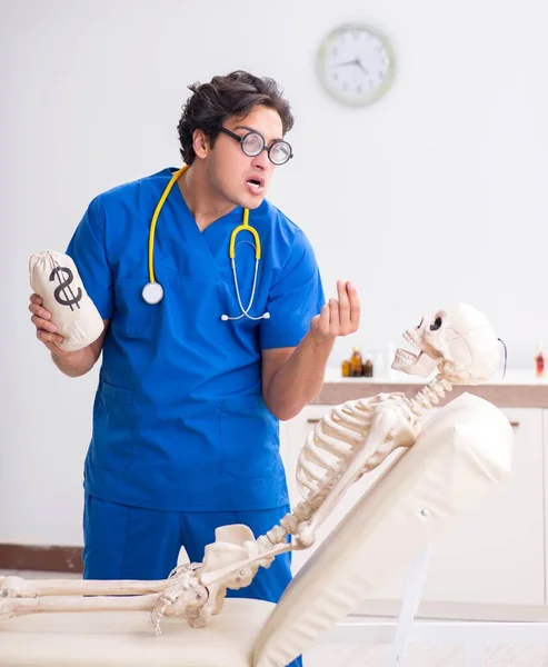 Doutor engraçado com esqueleto no hospital — Fotografia de Stock