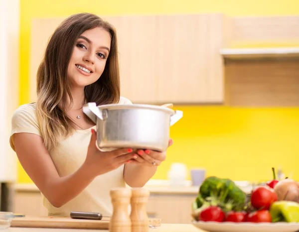 Giovane donna che cucina zuppa in cucina a casa — Foto Stock