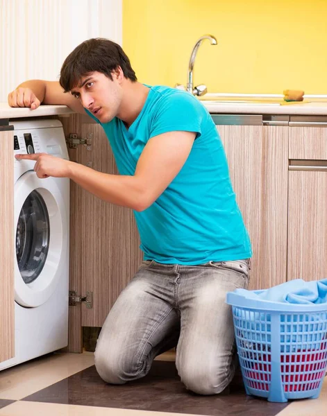 Joven marido hombre haciendo la colada en casa — Foto de Stock