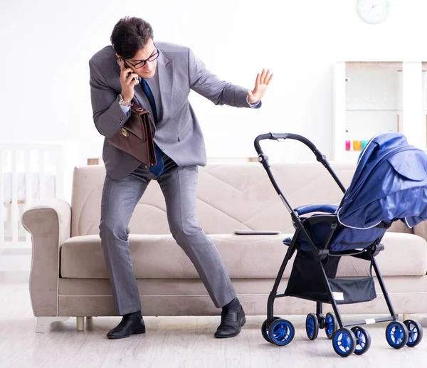 Businessman looking after newborn baby at home and teleworking — Stock Photo, Image