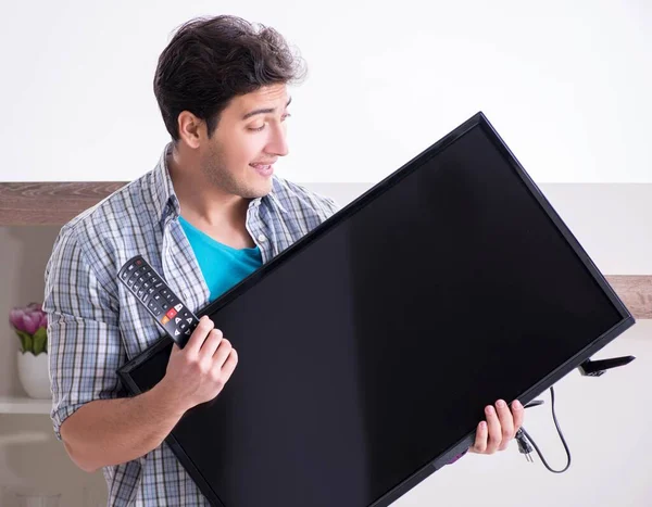 Man trying to fix broken tv — Stock Photo, Image