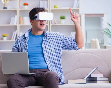 Evde sanal gerçeklik gözlükleriyle serbest çalışan bir öğrenci.