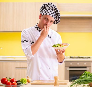 Genç profesyonel aşçı mutfakta salata hazırlıyor.