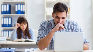 Sınıfta oturan ve okuyan öğrenciler