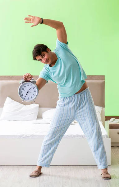 Young man in pajamas doing morning exercises