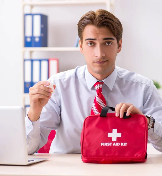 Man med första hjälpen kit på kontoret — Stockfoto