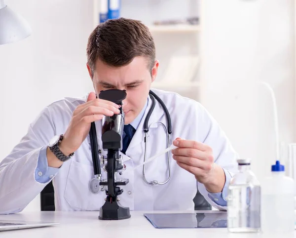 Männlicher Arzt schaut sich Laborergebnisse im Krankenhaus an — Stockfoto