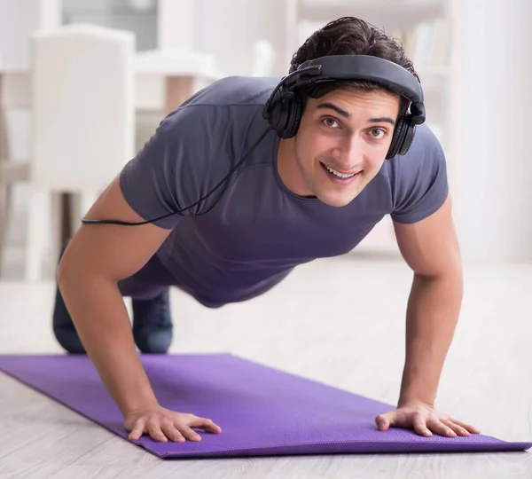 Hombre haciendo deportes en casa y escuchando música —  Fotos de Stock