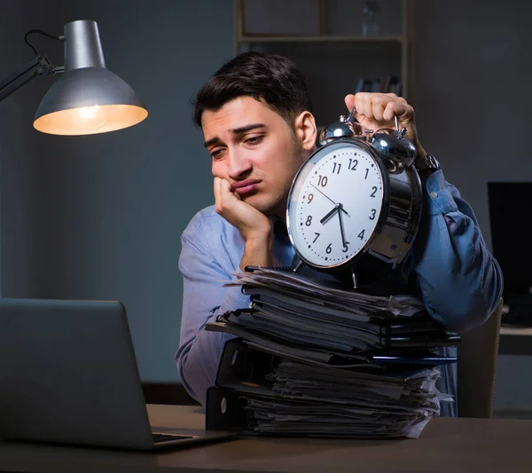 Jovem empregado que trabalha horas extras para cumprir prazo — Fotografia de Stock