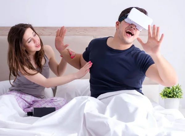 Esposa e marido com óculos de realidade virtual na cama — Fotografia de Stock