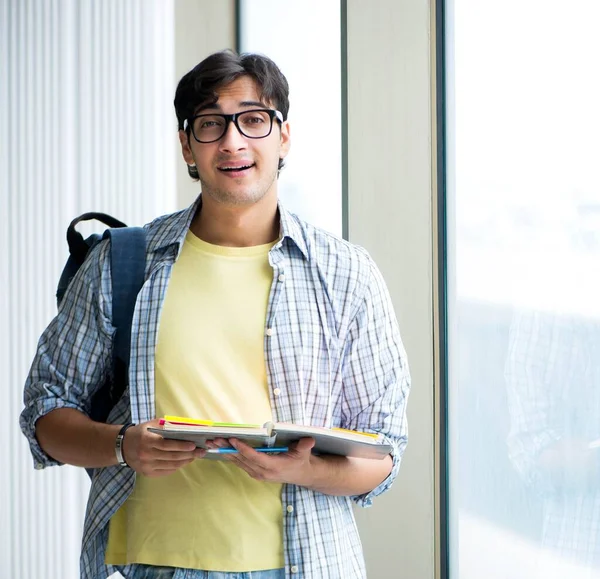 Ung stilig student står vid fönstret — Stockfoto