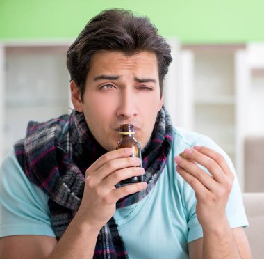 Evde hastalıktan muzdarip genç yakışıklı bir adam.