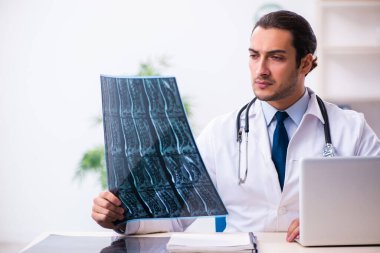Klinikte çalışan yakışıklı genç bir doktor.