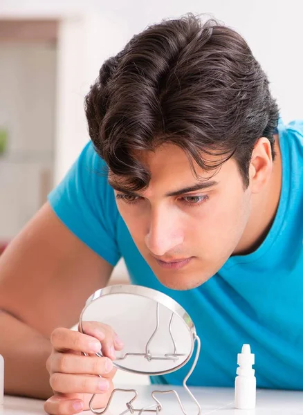 Homem tentando lentes de contato em casa — Fotografia de Stock