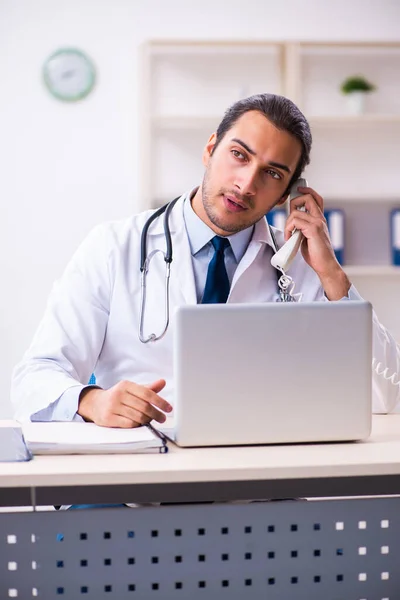 Jonge mannelijke knappe arts werkzaam in de kliniek — Stockfoto