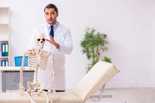 Mladý mužský lékař s kostrou — Stock fotografie
