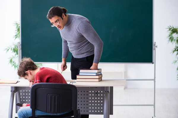 Giovane insegnante e scolaro maschio in classe — Foto Stock