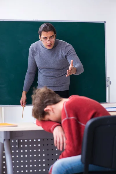 Jeune enseignant et écolier dans la salle de classe — Photo