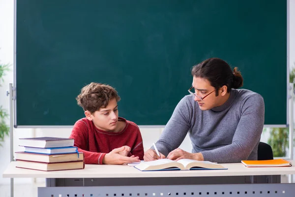 Jonge mannelijke leraar en schooljongen in de klas — Stockfoto