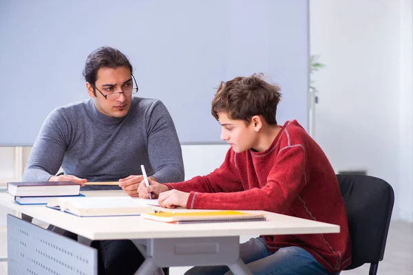 Giovane insegnante e scolaro maschio in classe — Foto Stock