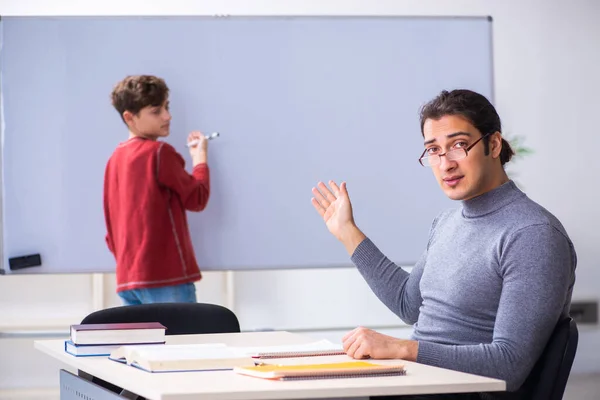 Jonge mannelijke leraar en schooljongen in de klas — Stockfoto