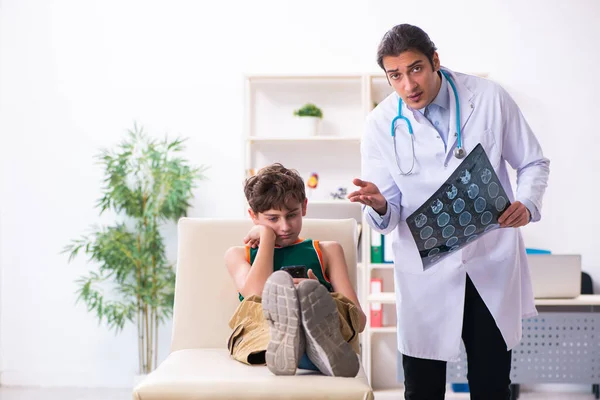 Chory chłopiec odwiedza młodego lekarza pediatrę — Zdjęcie stockowe