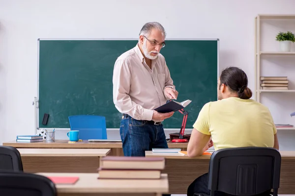 Viejo profesor y joven estudiante masculino en el aula — Foto de Stock